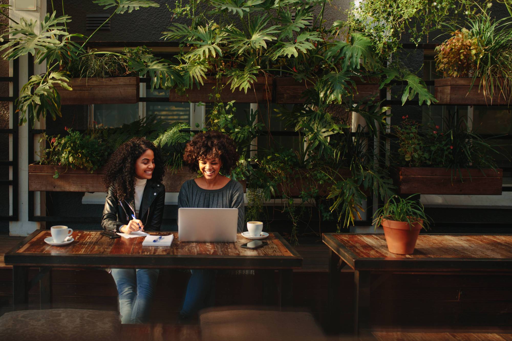 two individuals sitting at a table looking at a laptop